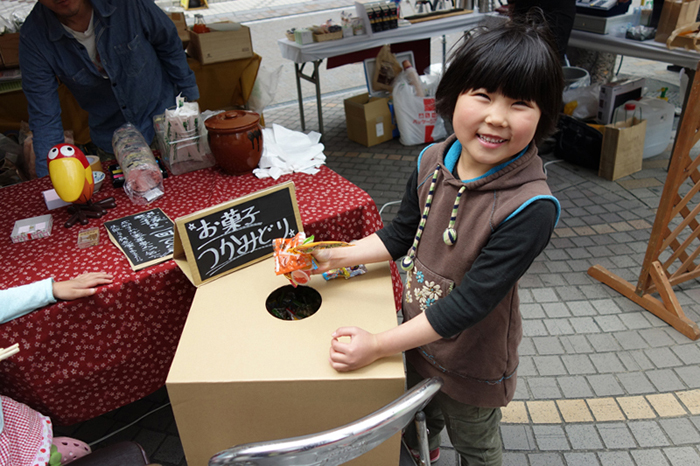 こどもが無地のつかみどりBOXから駄菓子を取り出している様子