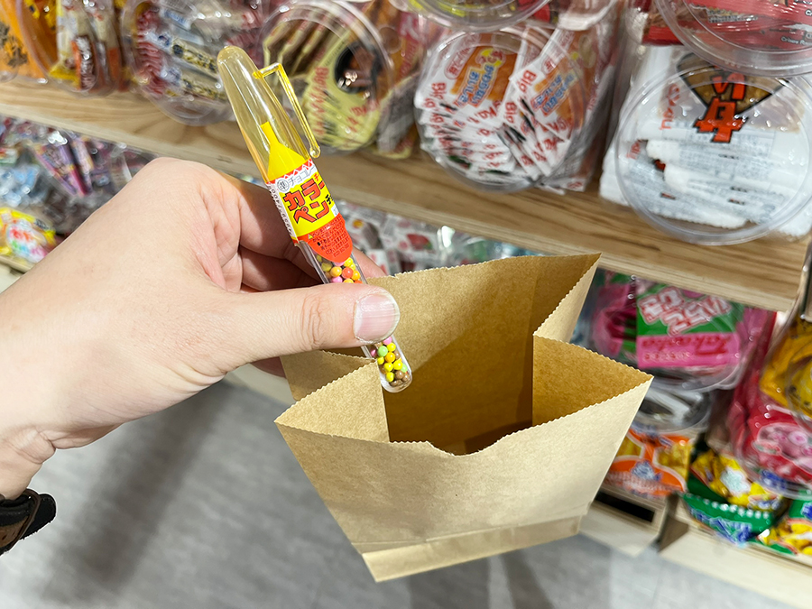 紙袋に駄菓子を入れている様子